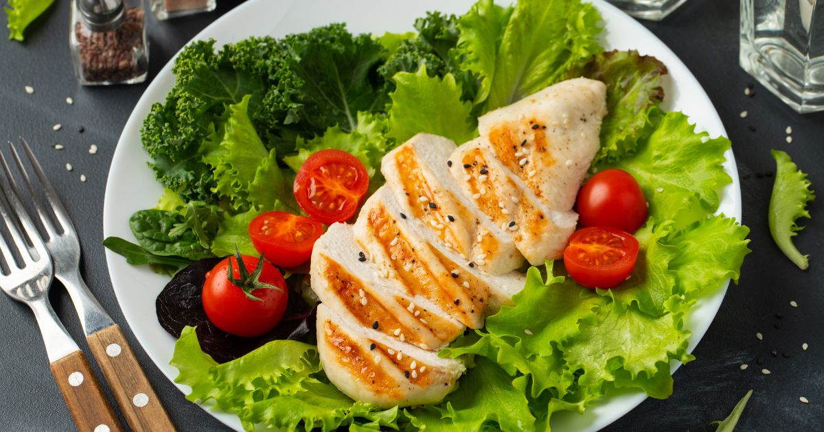 keto diéta — drevené písmená KETO DIET s avokádom, syrom a lososom
